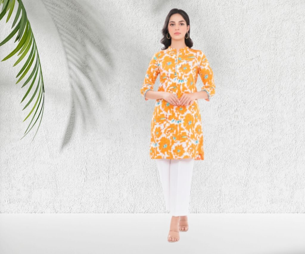 Model wearing Alkaram Studio summer lawn sale 2025 an orange floral kurta paired with white pants, standing against a minimalist background with a leafy accent