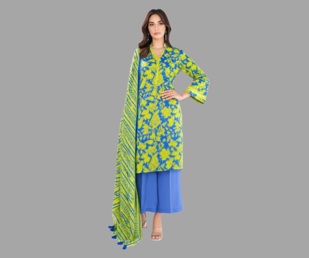 Model wearing Alkaram Studio summer lawn sale 2025 a vibrant neon blue and yellow floral kurta paired with matching palazzo pants, standing against a neutral background